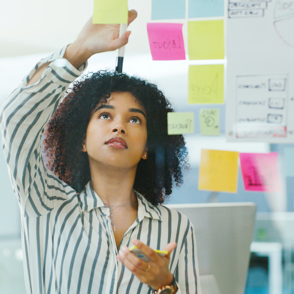 A career counselor focuses intently while arranging colorful sticky notes on a board